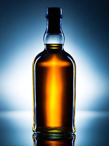 A bottle of liquor with dramatic light.